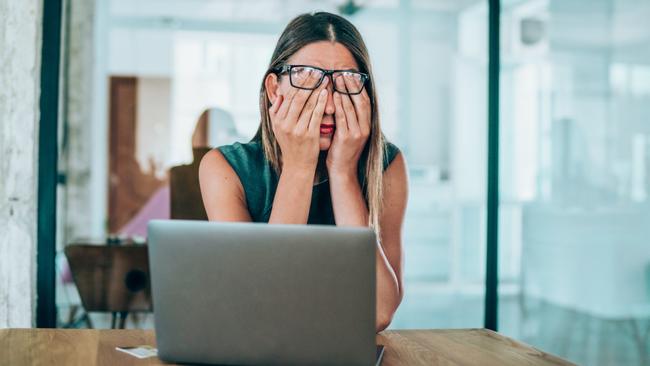 Employee with head in hands reflecting a worker unsure if they have met the ‘minimum employment period’ to make an unfair dismissal claim