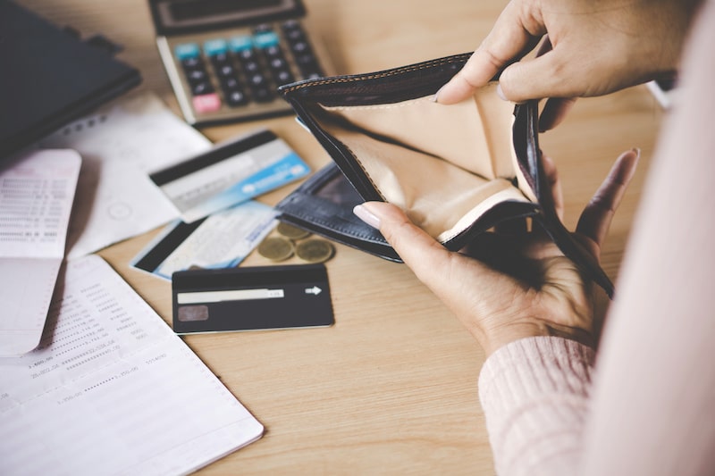 Person holding open an empty wallet to reflect a business facing bankruptcy or insolvancy
