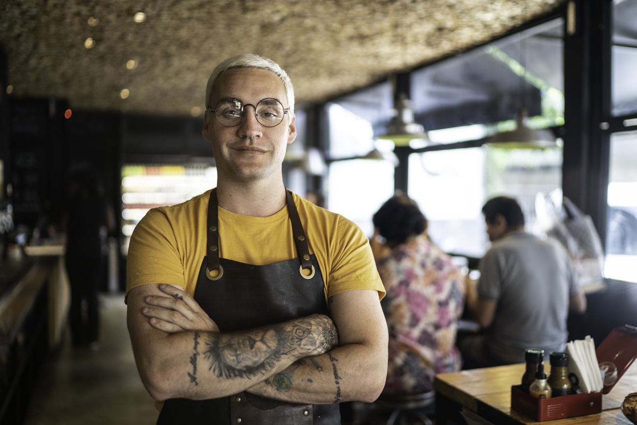 Hospitality worker who may be impacted by the casual employee definition standing with arms closed