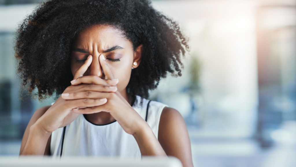 Employee clasps hands in front of face in stress after receiving a written warning
