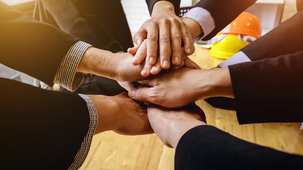 hands stacked on top of each other representing employees and employers reaching an enterprise agreement