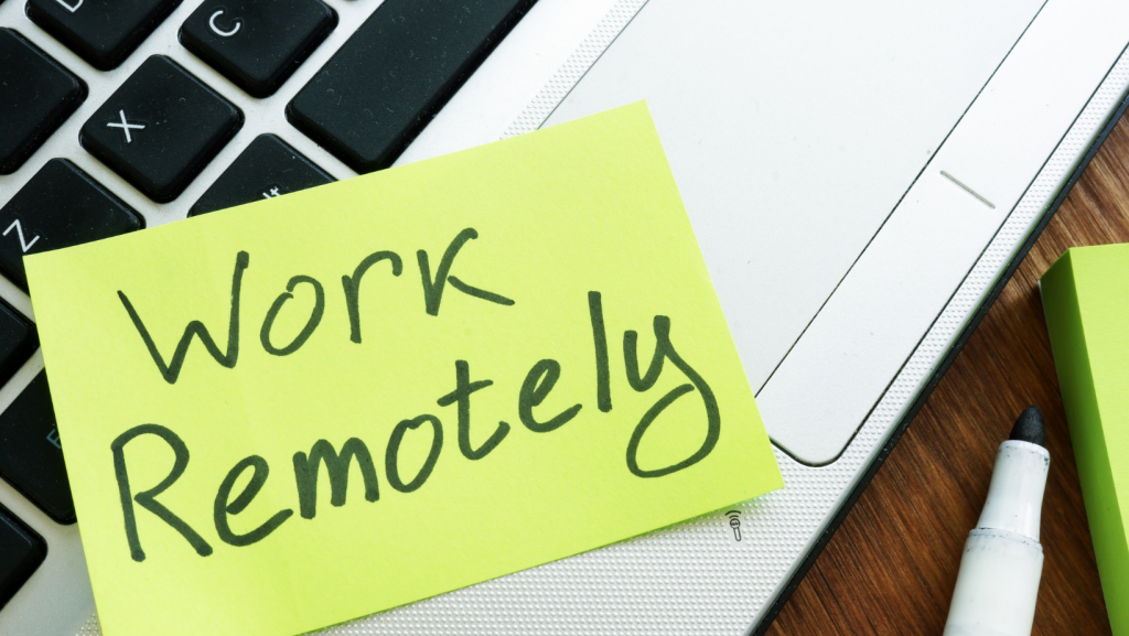 Laptop keyboard with "work remotely" on a post it note.